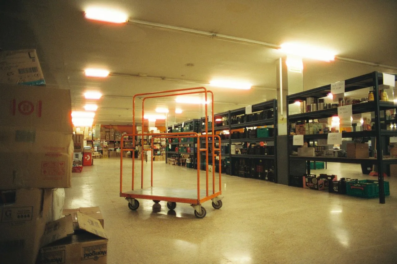 Warehouse interior with shelving, stock and a logistics cart