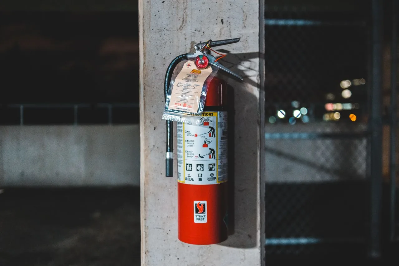 Fire extinguisher with a maintenance tag mounted on a concrete column