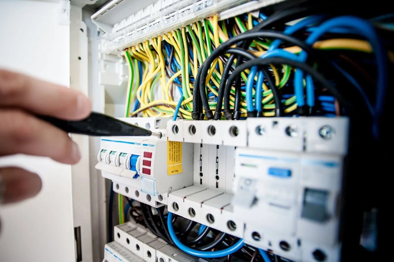 Electrician working on a consumer unit with coloured wiring