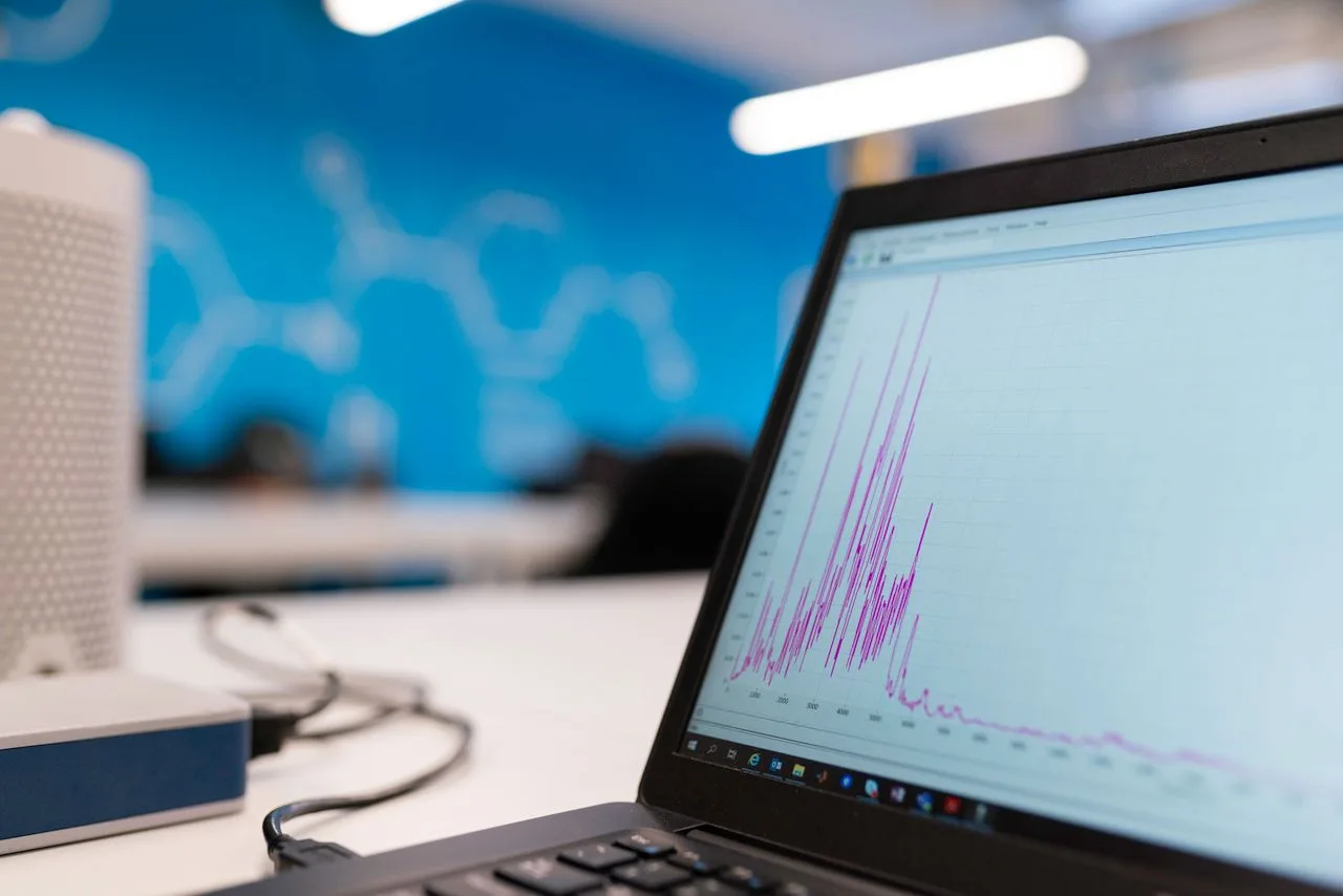 Laptop on a desk showing a line chart of business data
